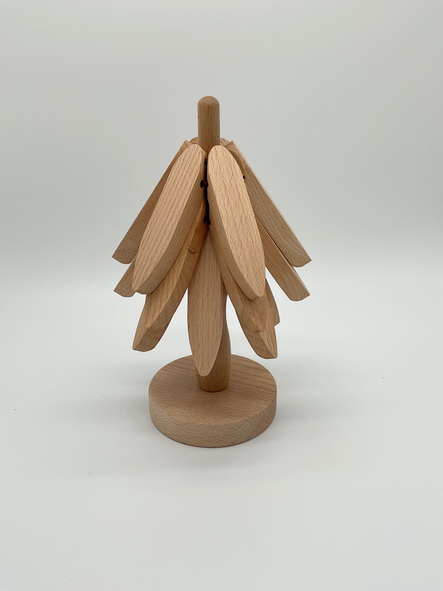 A wooden trivet designed to resemble a tree with multiple branches, which is actually a stack of trivets designed to be placed on top of each other.