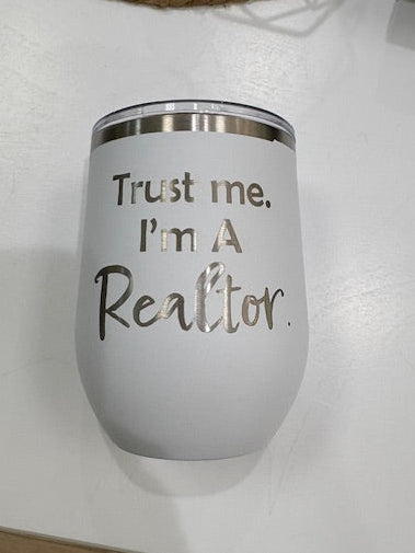 White tumbler with 'Trust me, I'm a Realtor' text on a white surface.