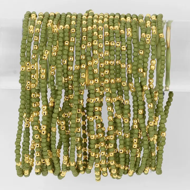 Green and gold beaded strands on a white background
