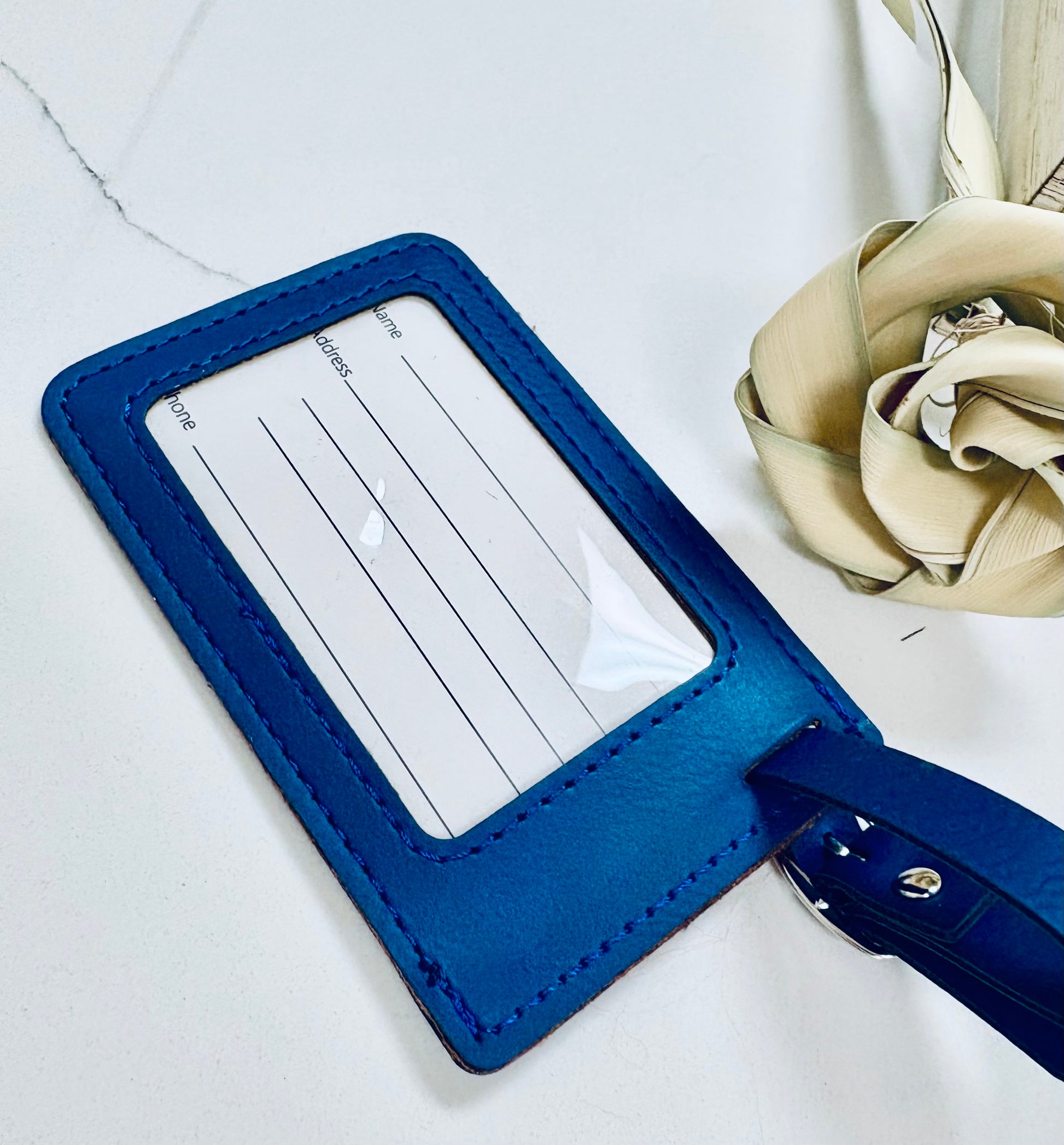Locally engraved in Charleston Blue luggage tag with a clear window for ID on a light gray background