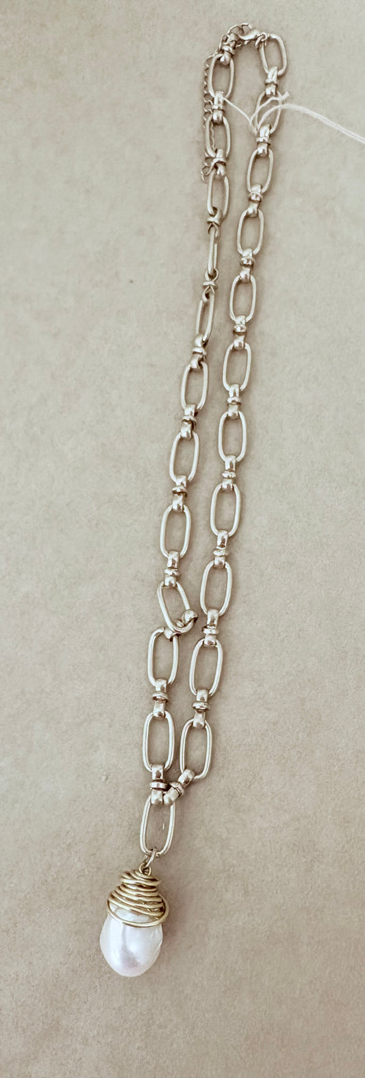 Silver chain necklace with a pearl pendant on a beige background~ local Charleston jewelry