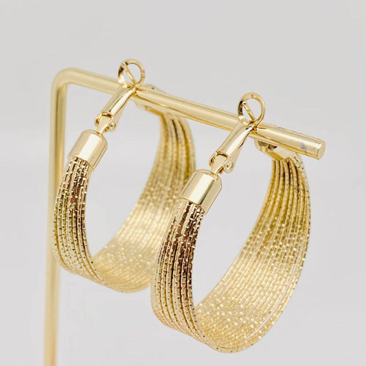 Gold hoop earrings on a light gray background
