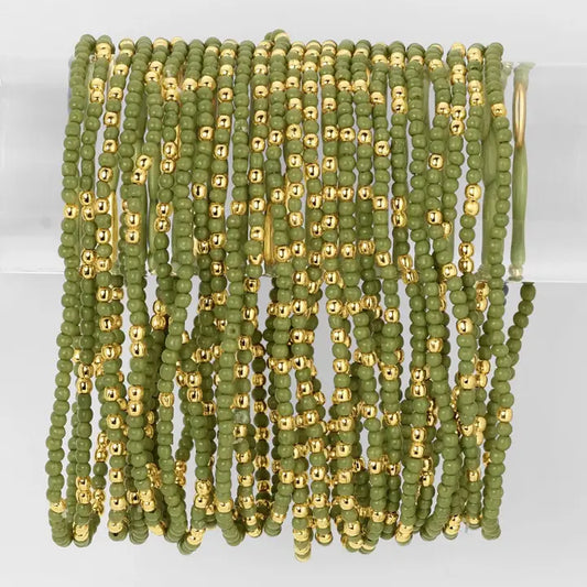 Green and gold beaded strands on a white background