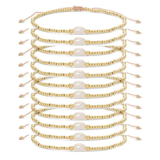 Set of gold beaded bracelets with pearls on a white background